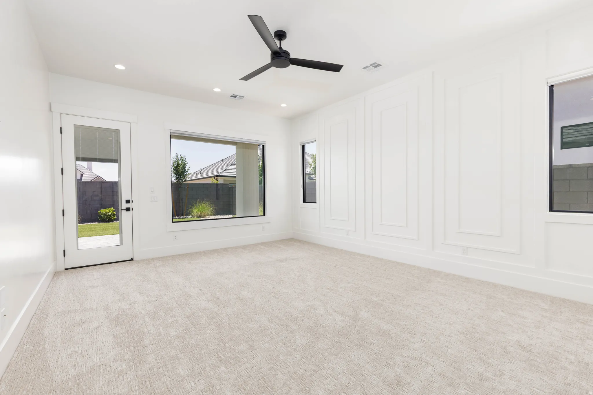 Spacious room featuring a decorative accent wall, recessed lighting, and a contemporary ceiling fan