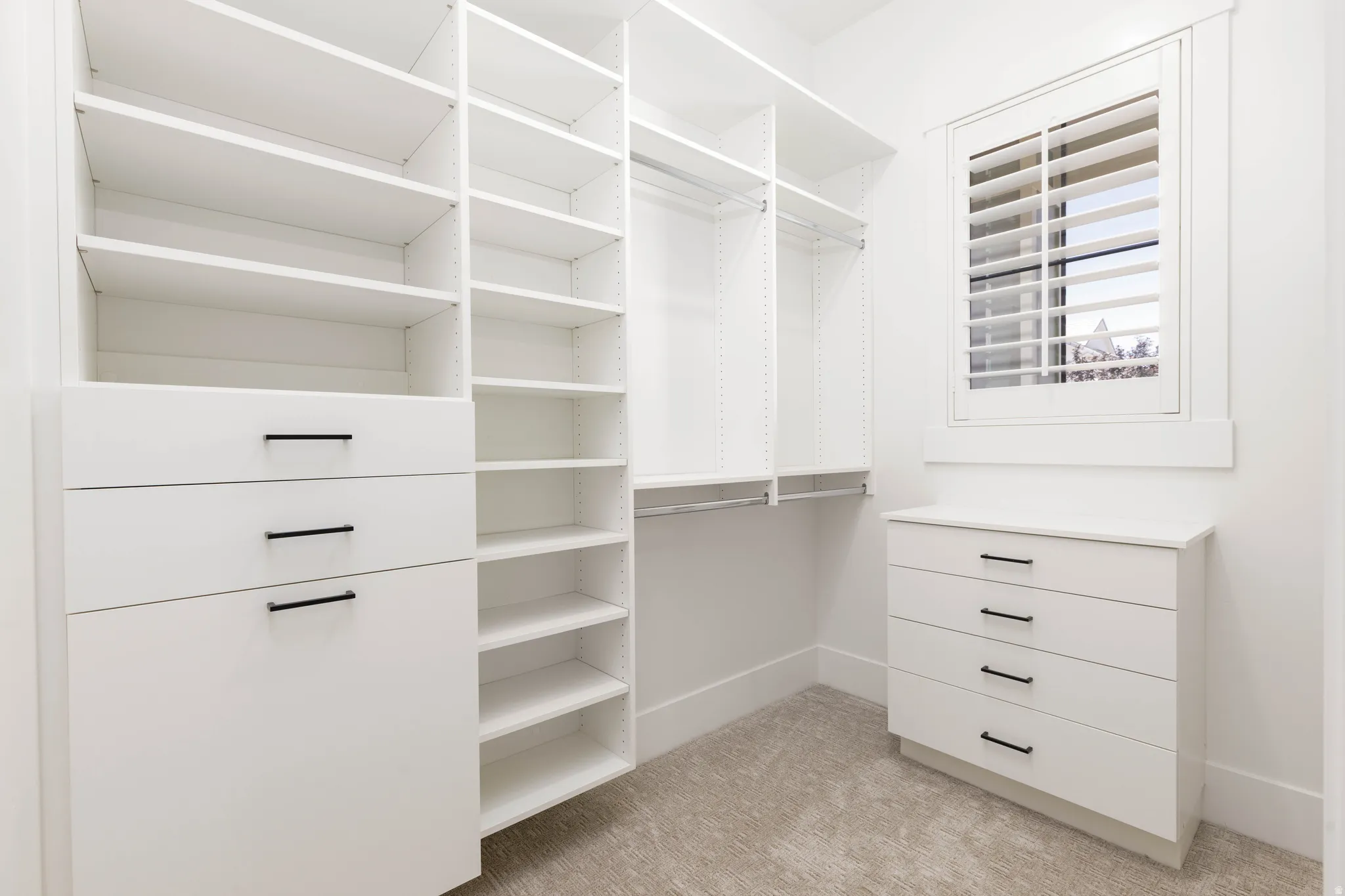 Custom closet system featuring extensive shelving and built-in drawers with matte black hardware