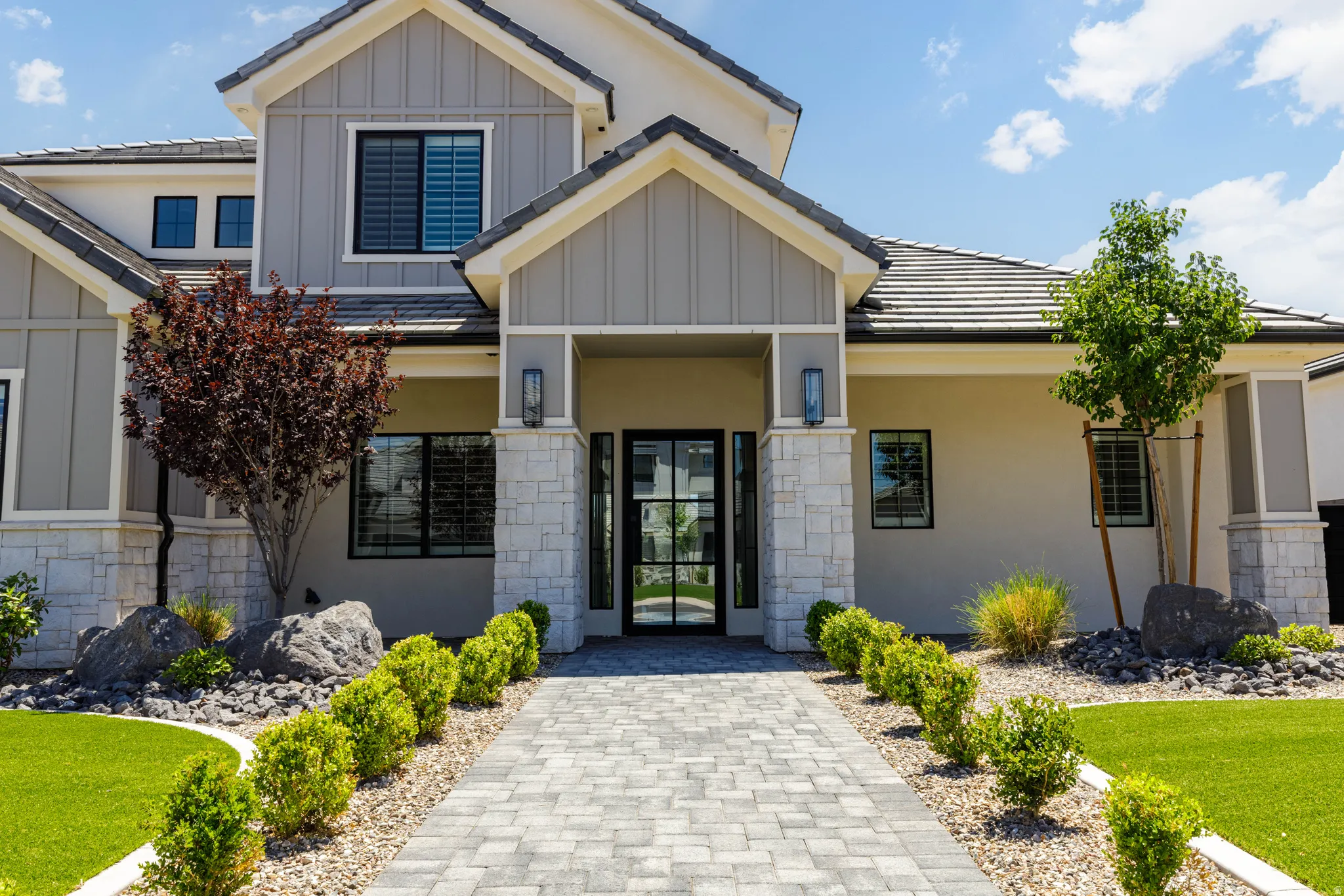 Contemporary facade featuring board and batten siding with stone accents