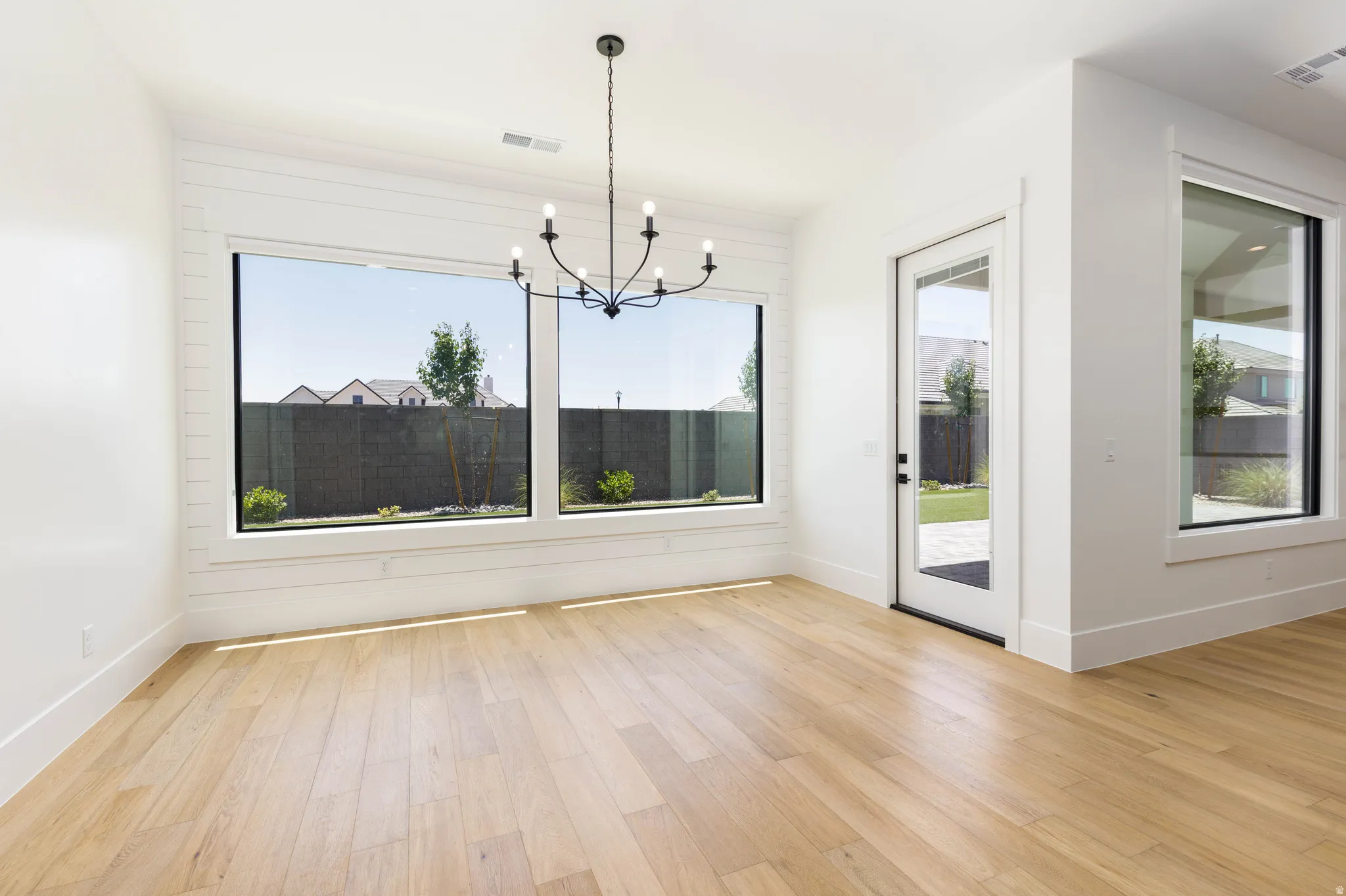 Light wood-finish flooring complements the bright white walls and trim