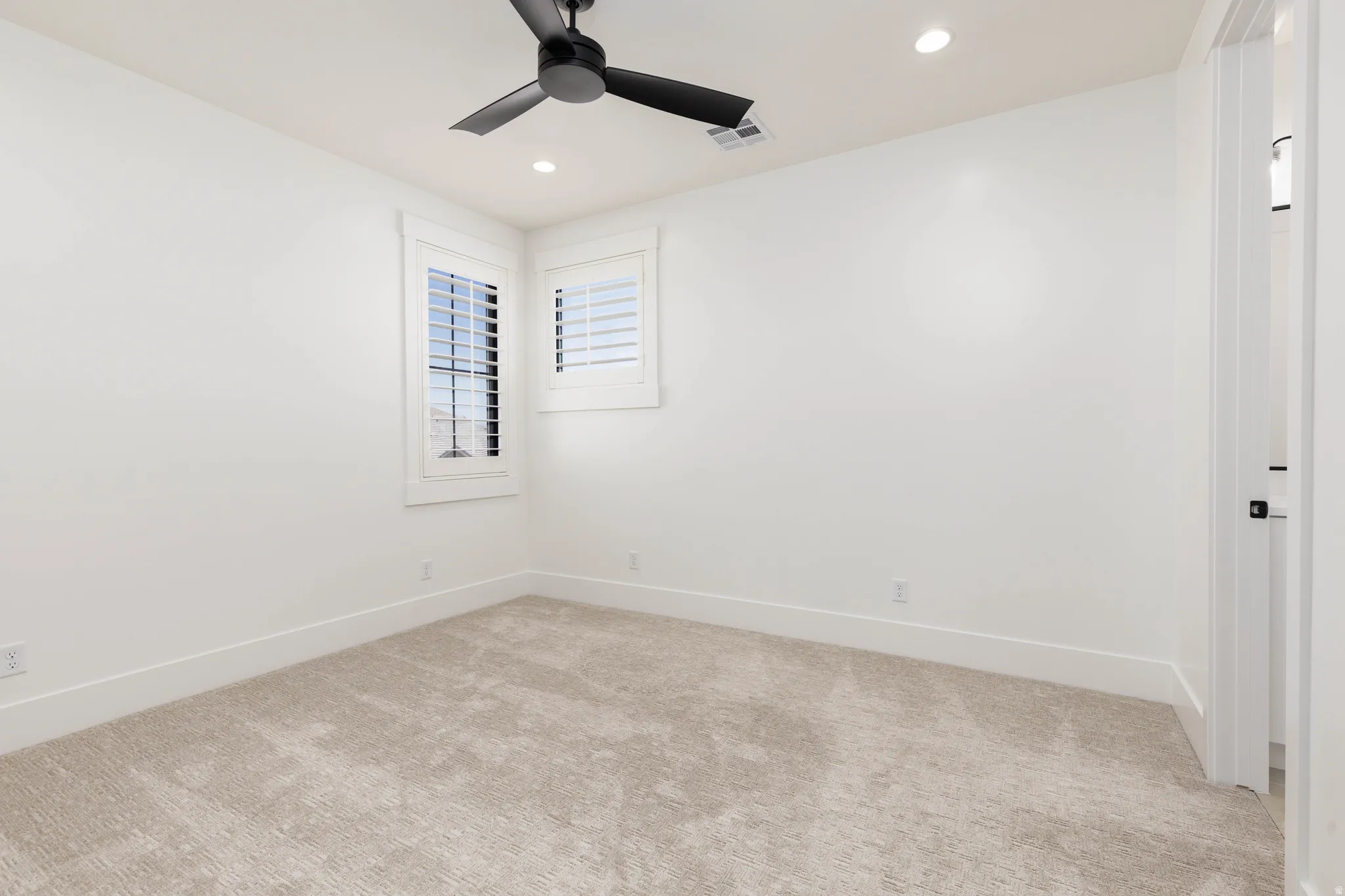 Neutral tone carpeting with white baseboards throughout