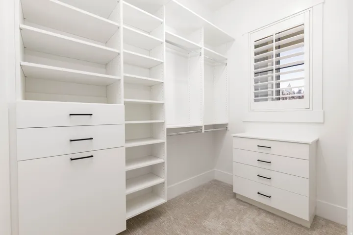 Custom closet system featuring extensive shelving and built-in drawers with matte black hardware