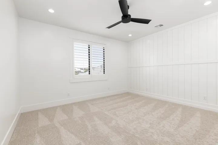 Neutral-toned carpet flooring complements the white walls and trim