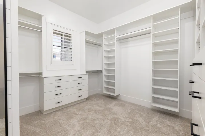 Custom closet system featuring extensive shelving, hanging rods, and built-in drawers with matte black hardware