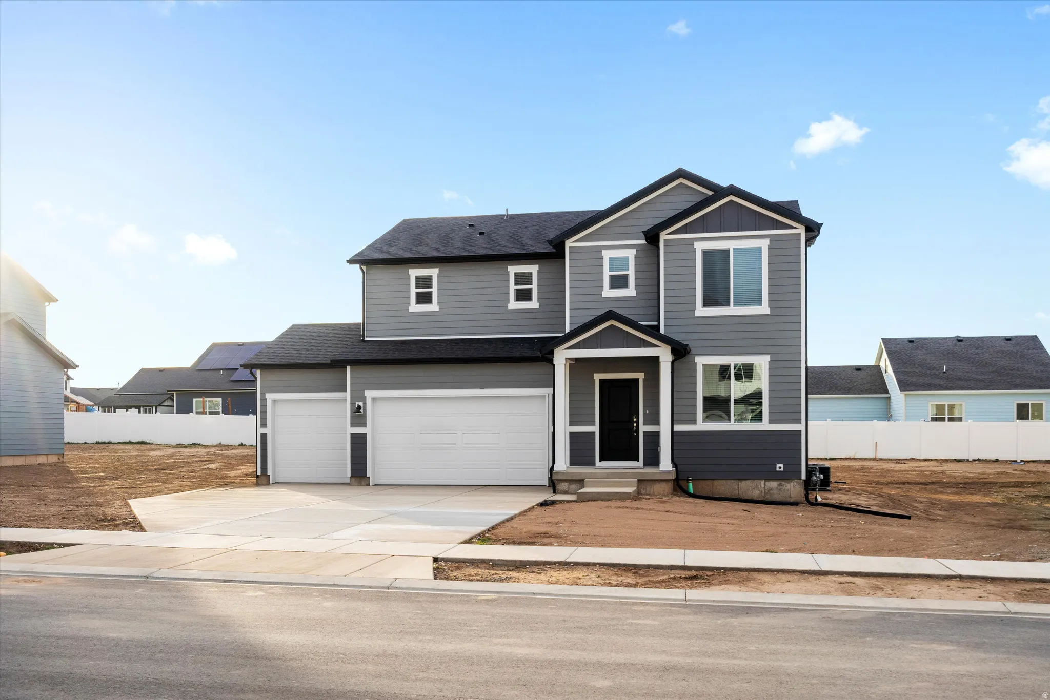 Contemporary two-story residence featuring grey siding, a black shingle roof, and a two-car attached garage