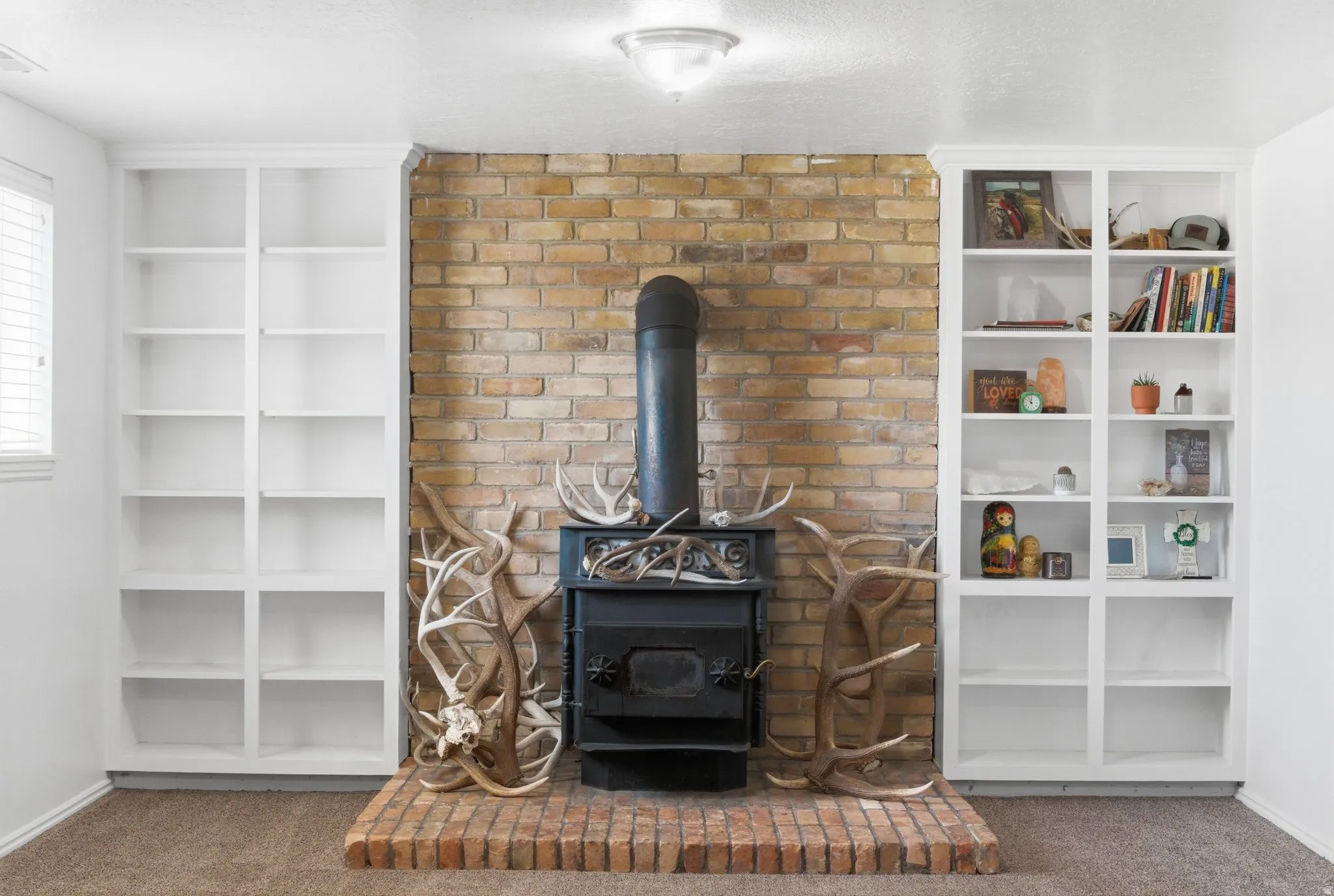 Brick-faced wall with a black wood-burning stove and a brick hearth