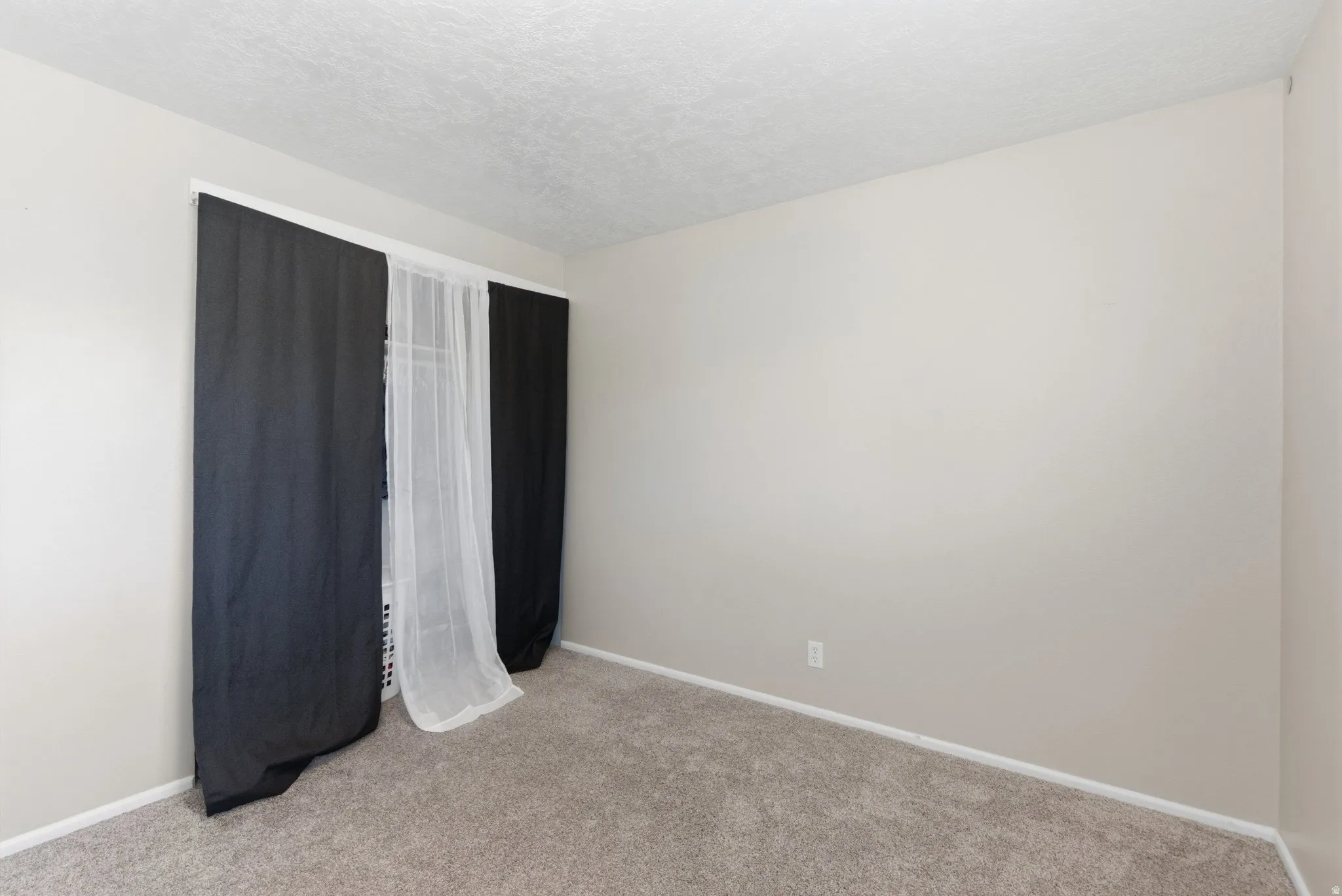 Carpeted interior space with light-toned walls and white trim