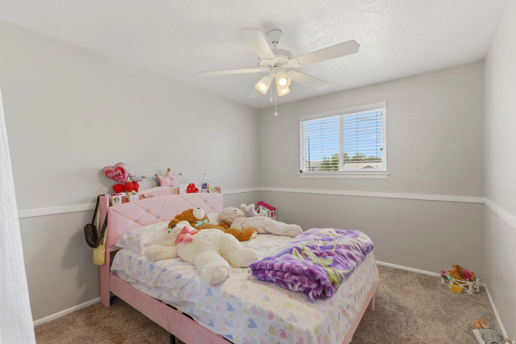 Carpeted room featuring a ceiling fan with integrated lighting, a single window with blinds, and white trim molding