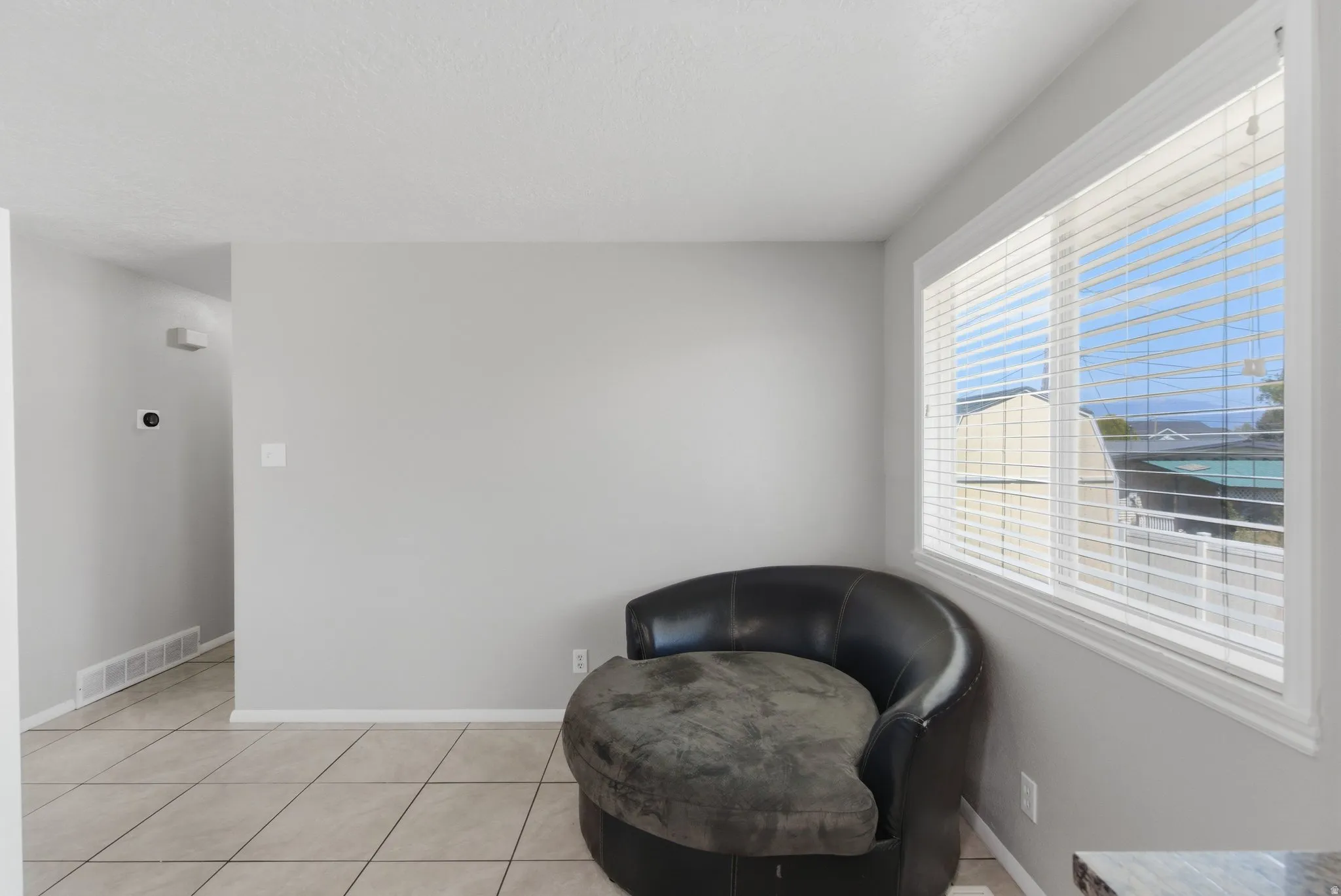 Neutral gray wall finishes, white window trim, and tile flooring with light grout lines