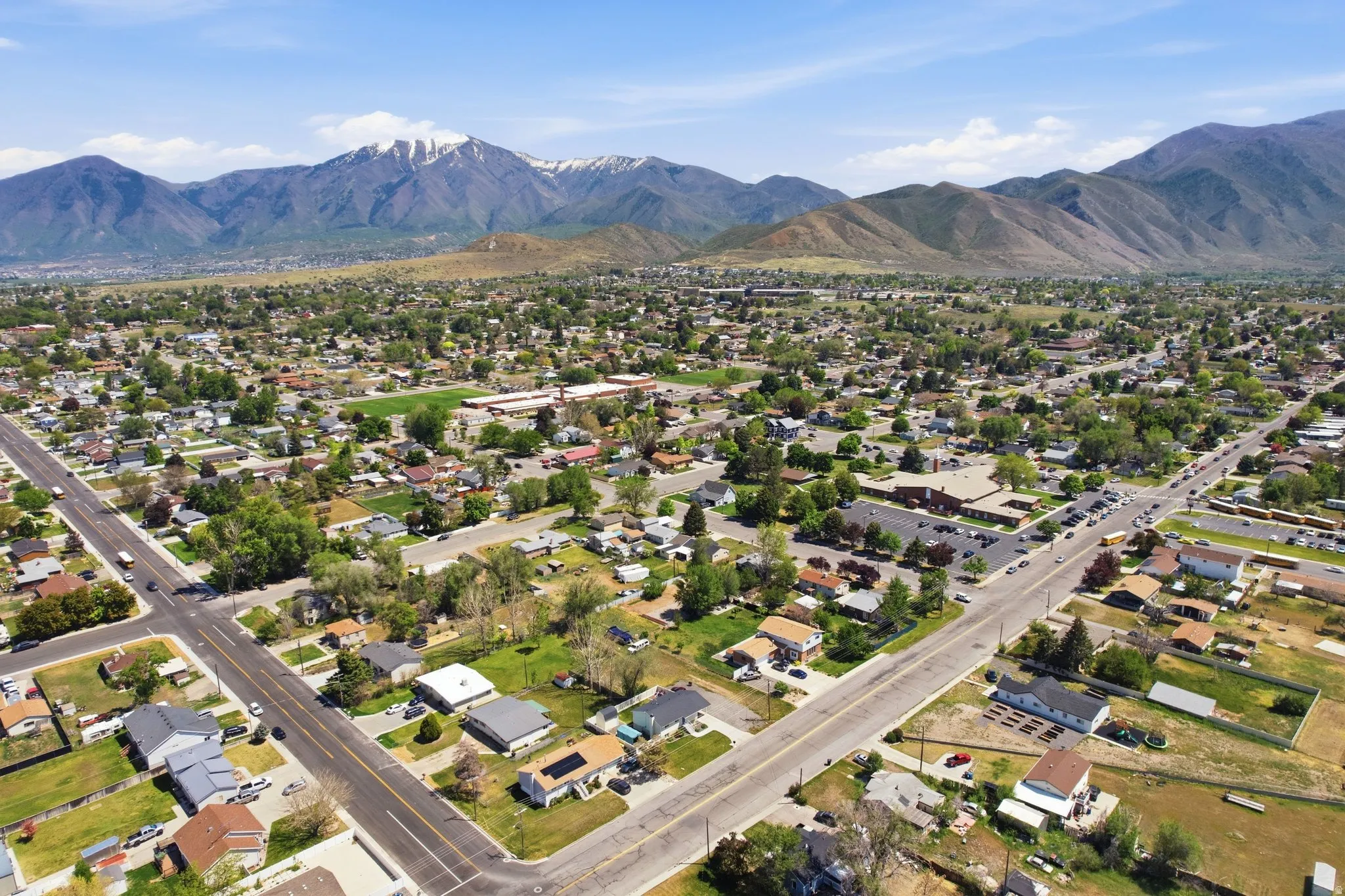Expansive aerial perspective showcasing a residential neighborhood with a mountain backdrop
