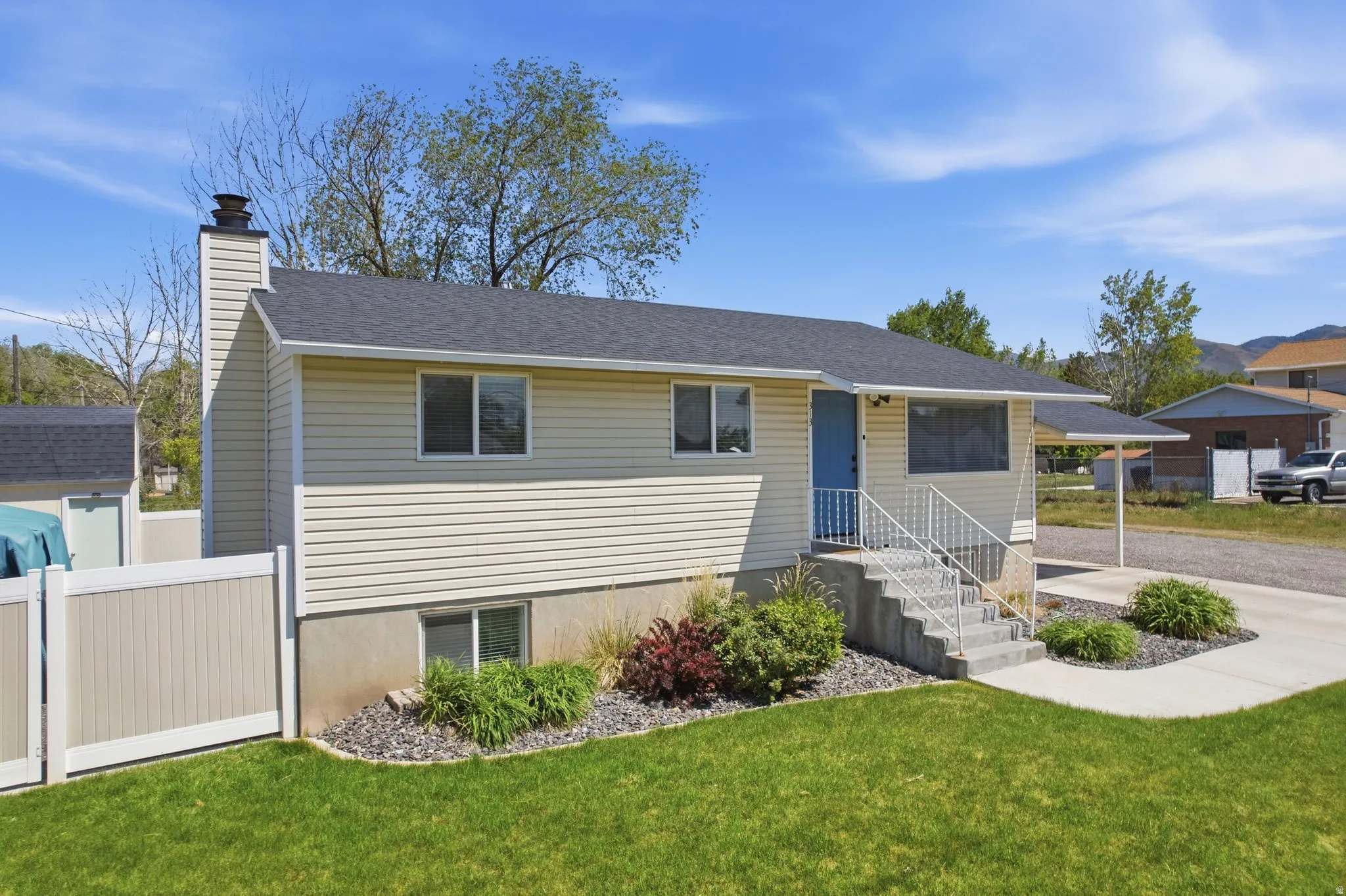 Ranch-style exterior with light-toned siding and a contrasting dark roof