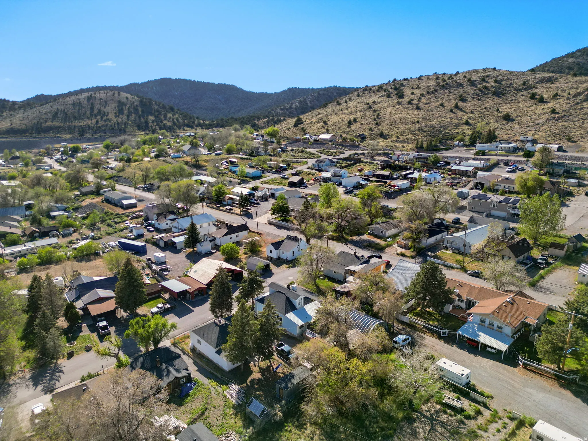 Expansive aerial perspective showcasing a residential community nestled within a mountainous landscape
