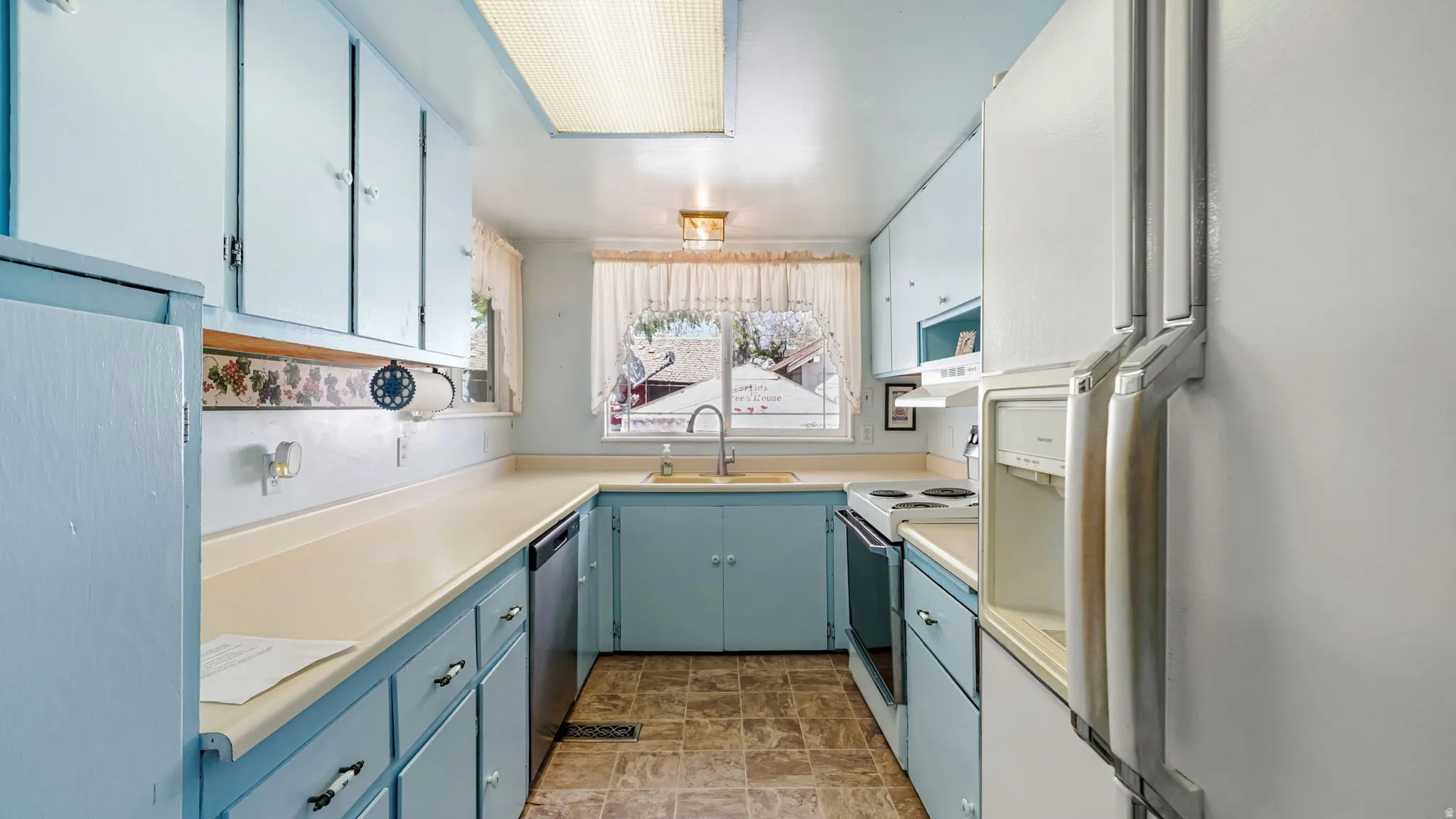 Kitchen featuring light blue cabinetry, light-toned countertops, and a U-shaped configuration