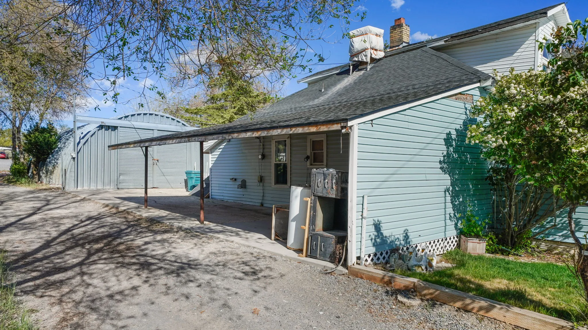 Rear exterior featuring light blue siding and a covered outdoor area with a sloped roof