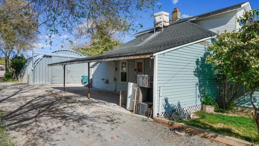 Rear exterior featuring light blue siding and a covered outdoor area with a sloped roof