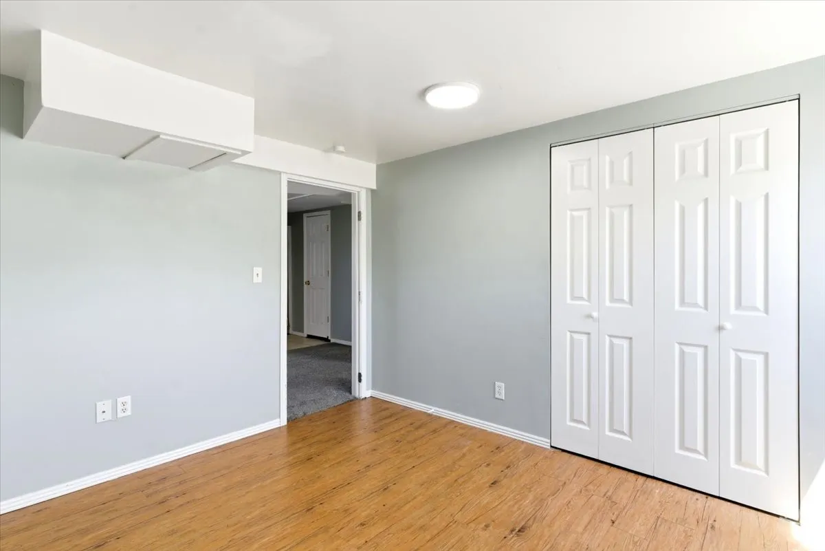 Light-toned wood-finish flooring complements the neutral wall color