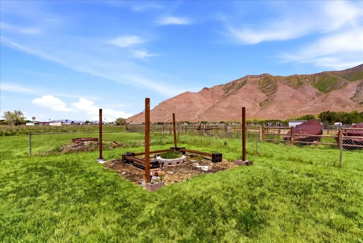 Expansive green space featuring an established garden bed with wood framing and four corner posts