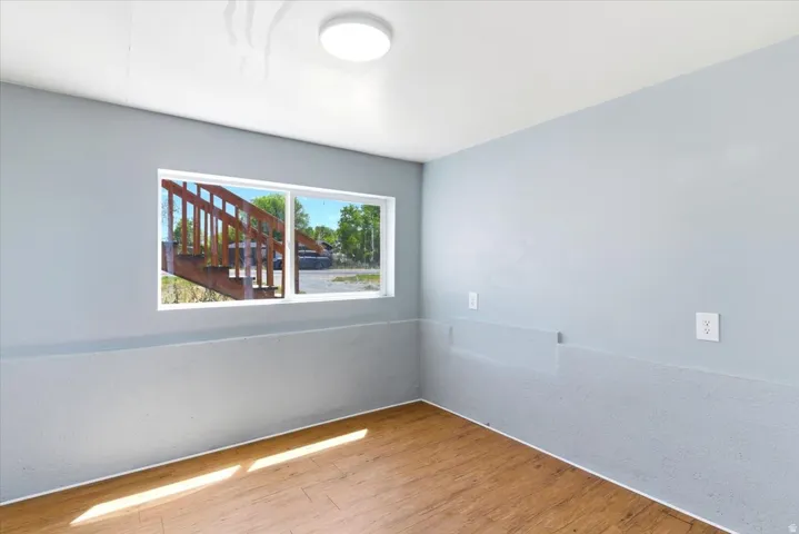 Wood-finish flooring with light blue walls and a white window frame