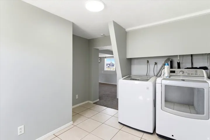 Utility area featuring tiled flooring, a built-in shelf, and light gray wall paint