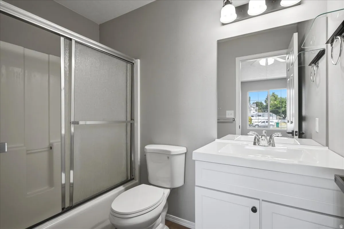 White vanity with integrated sink, chrome faucet, and a large mirror