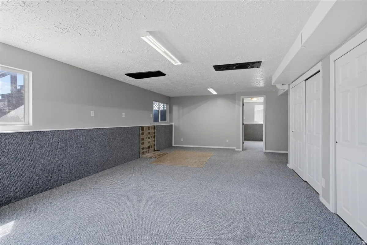 Spacious room featuring carpeting, multiple windows, built-in closets, and recessed lighting