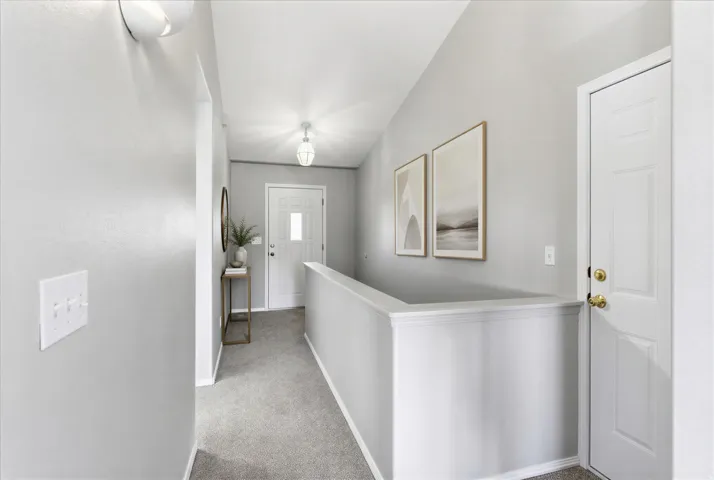 Entryway featuring light gray walls, plush gray carpeting, white trim, and a white paneled door with a rectangular glass insert