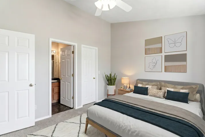 Carpeted bedroom featuring a vaulted ceiling and a ceiling fan