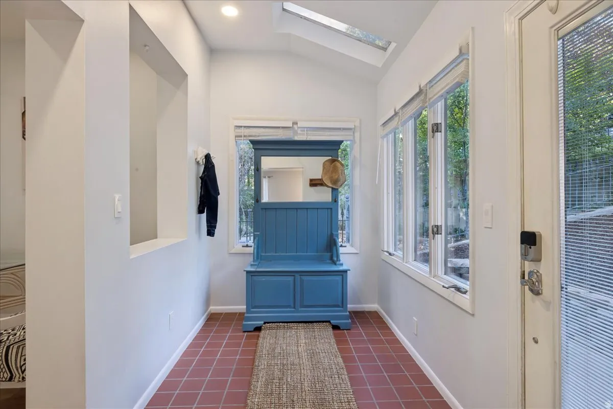 Entryway featuring terracotta tile flooring, vaulted ceiling, recessed lighting, and a skylight