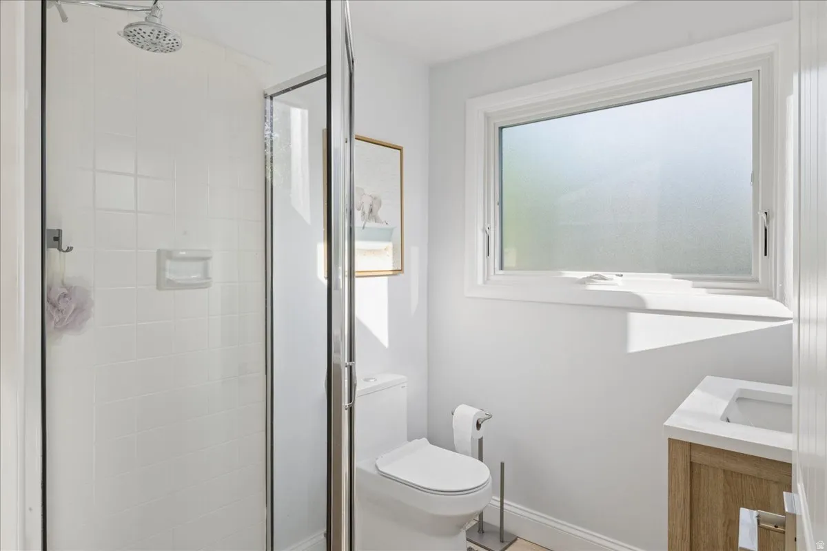 Shower with a clear glass enclosure and white tile surround
