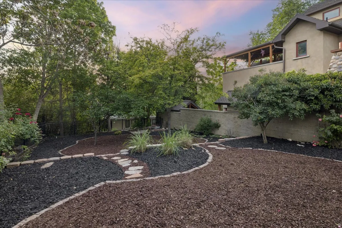 Landscaped backyard featuring layered mulch beds in dark and brown tones