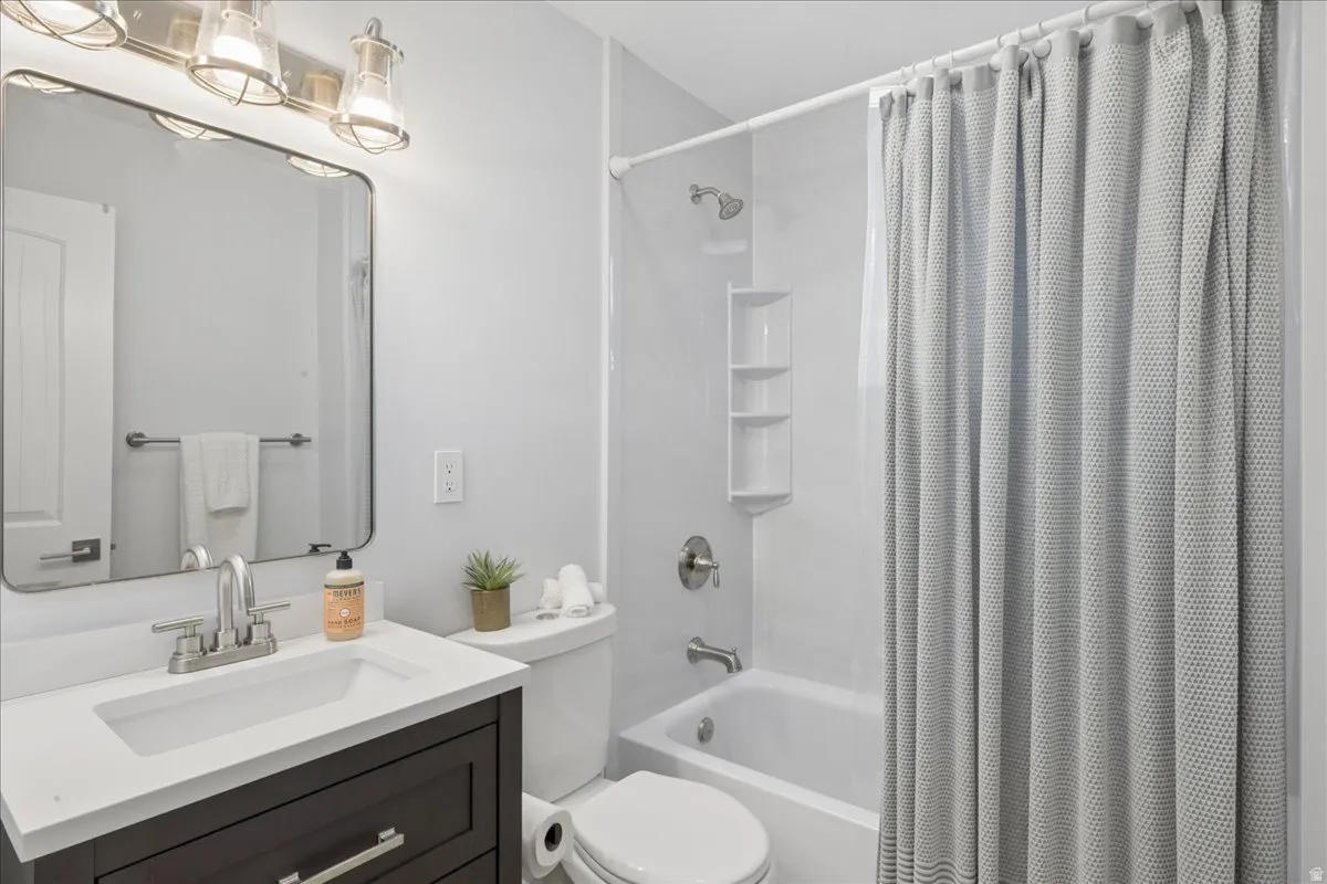 Bathroom featuring a dark wood-finish vanity with a white countertop, an undermount sink, and a brushed nickel faucet