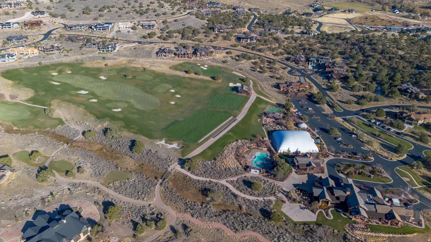 Expansive golf course with manicured greens and fairways, surrounded by residential properties and natural desert landscape