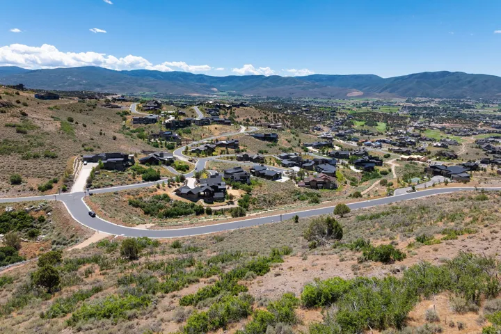 Sprawling hillside community with paved roads, mature landscaping, and surrounding mountainous terrain
