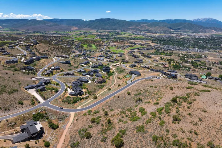 Hillsides with natural landscaping, paved roads, and residential structures