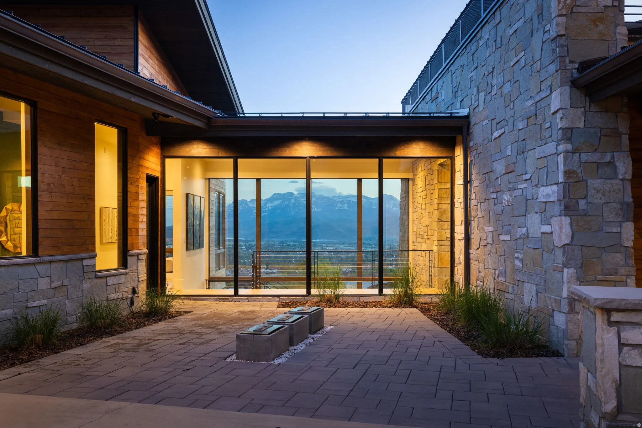Paver stone entrance with integrated landscaping and modern water features