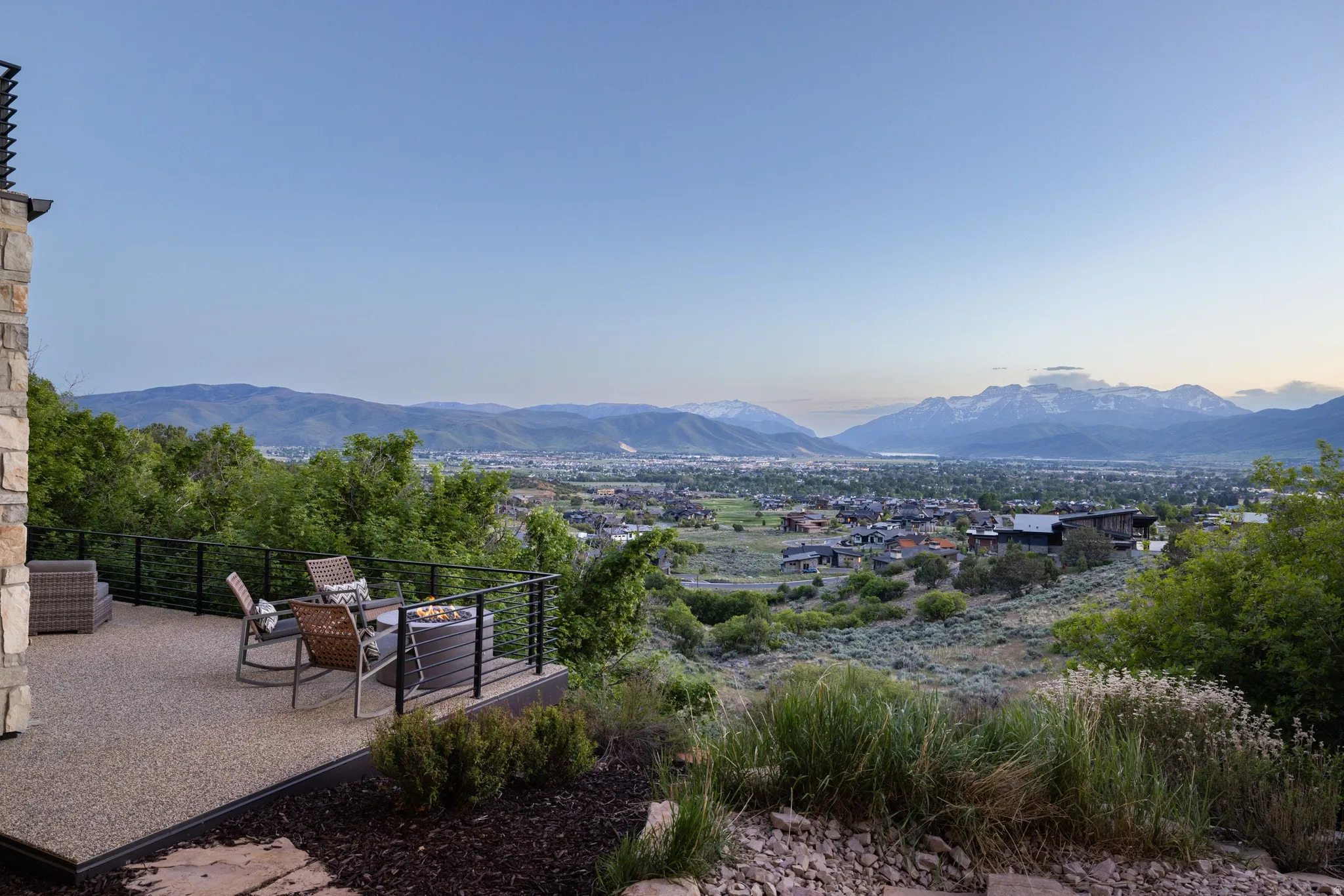 Expansive outdoor patio featuring an exposed aggregate finish and a black metal railing system