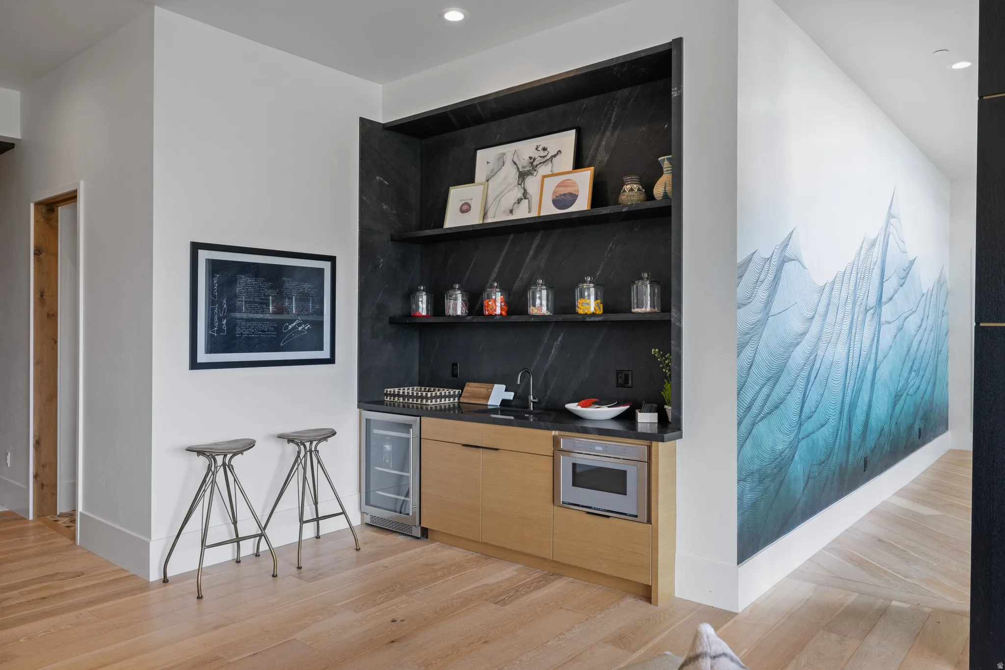 Integrated wet bar with wood-finish cabinetry, built-in beverage cooler, and microwave