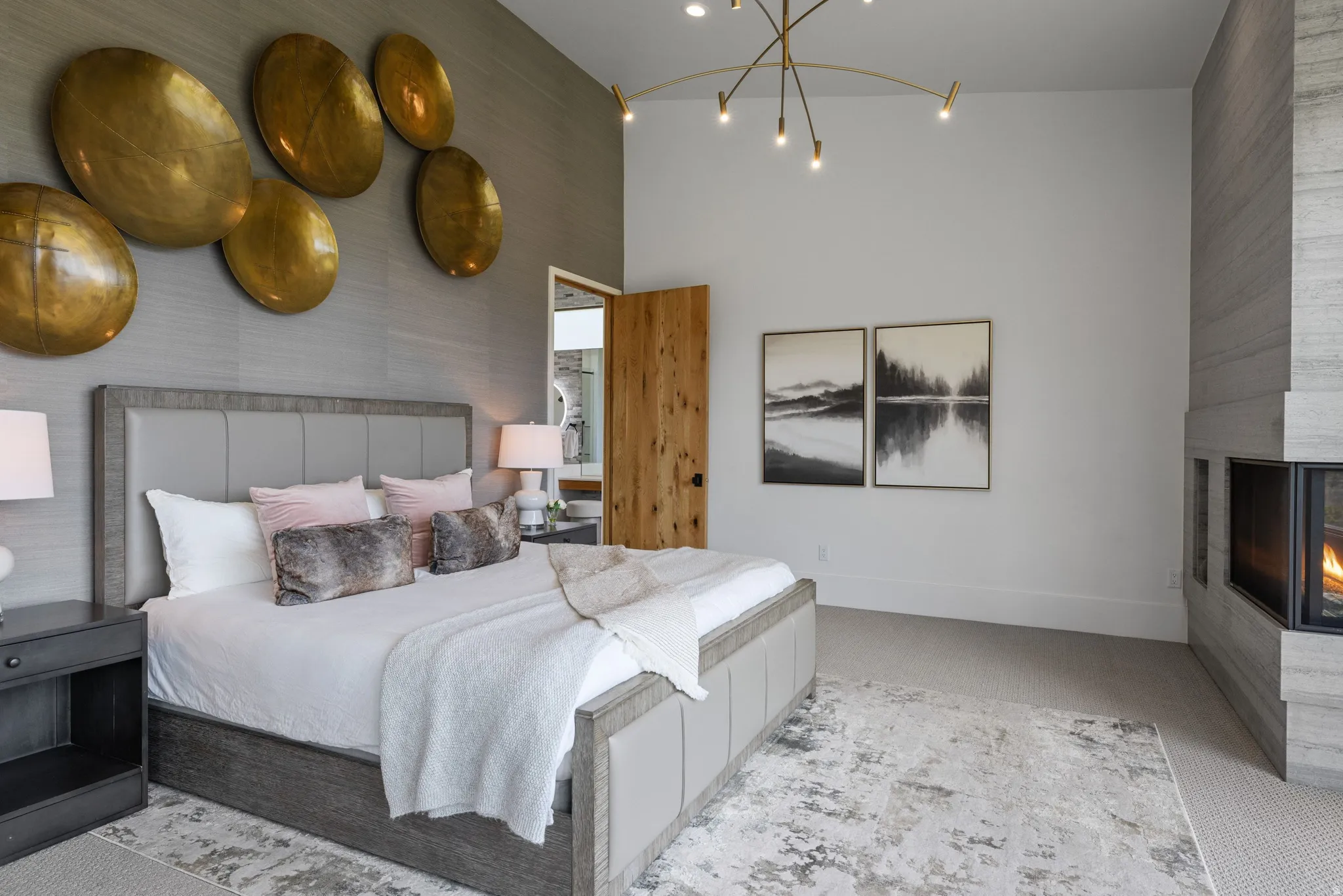 Spacious sleeping area featuring a vaulted ceiling and a stacked stone fireplace with a horizontal hearth