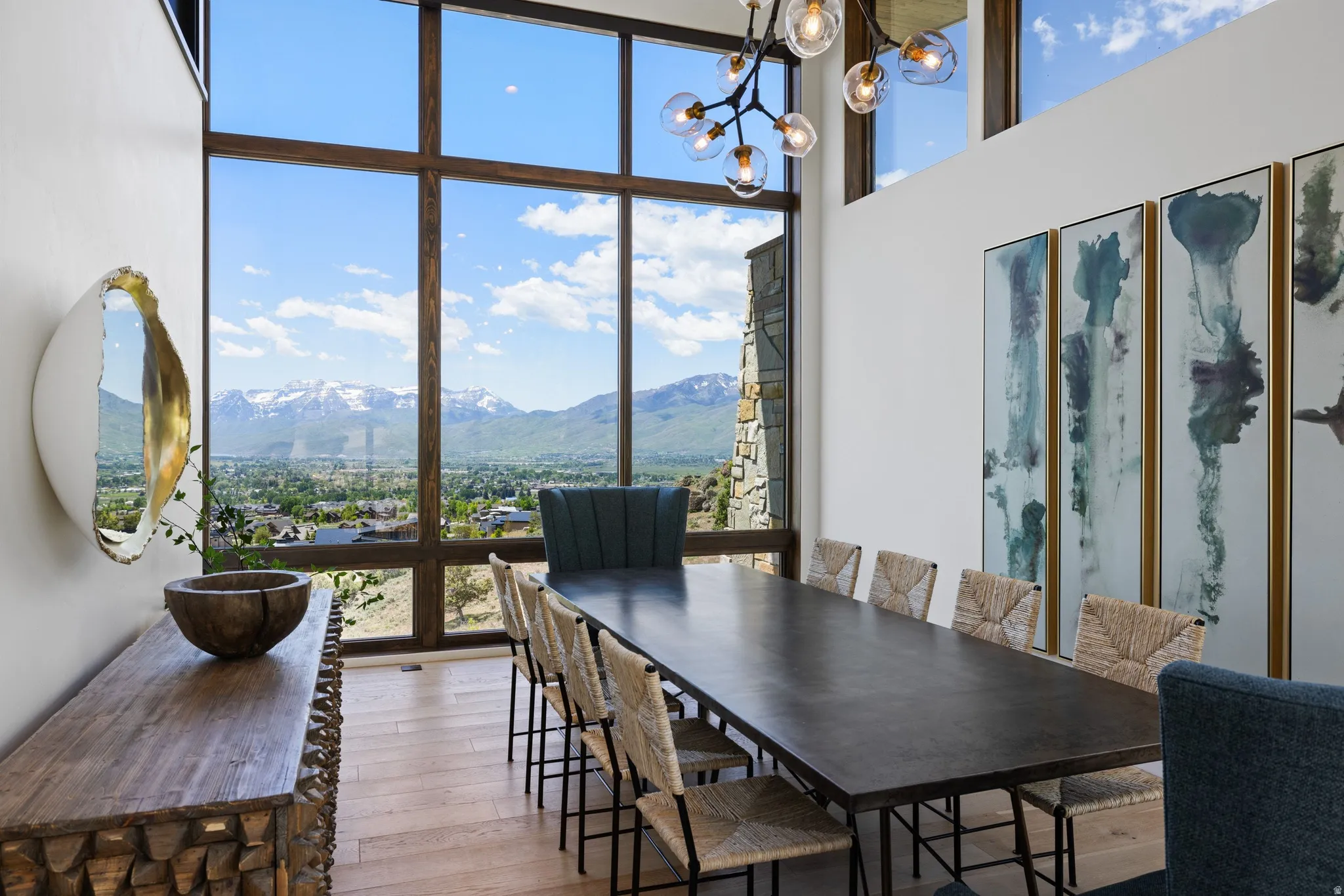 Two-story window wall with dark wood trim framing mountain and valley scenery