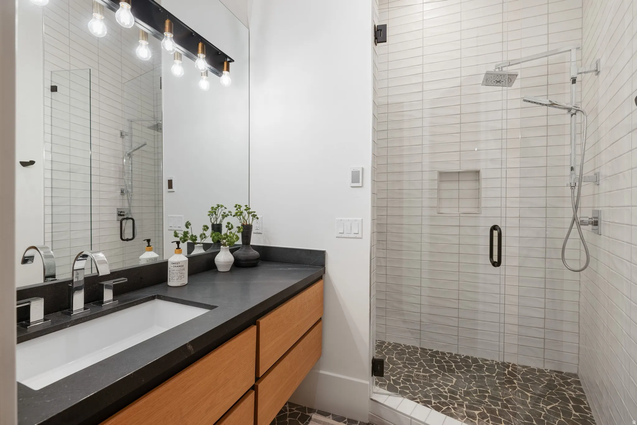Bathroom featuring a floating wood-finish vanity with a dark countertop and integrated rectangular sink