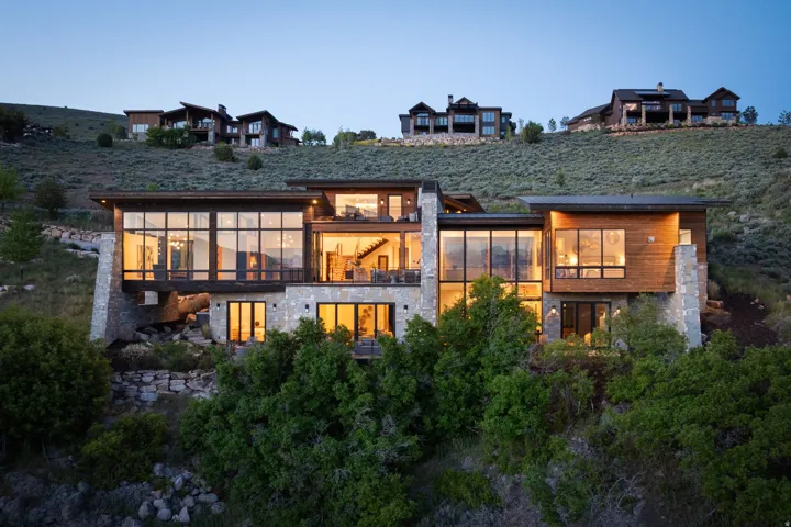 Modern architectural design featuring extensive glass fenestration, wood siding, and stone accents