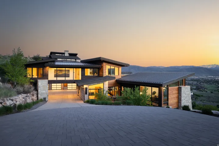 Modern architectural residence featuring a multi-level design, wood-finish siding, and stone accents
