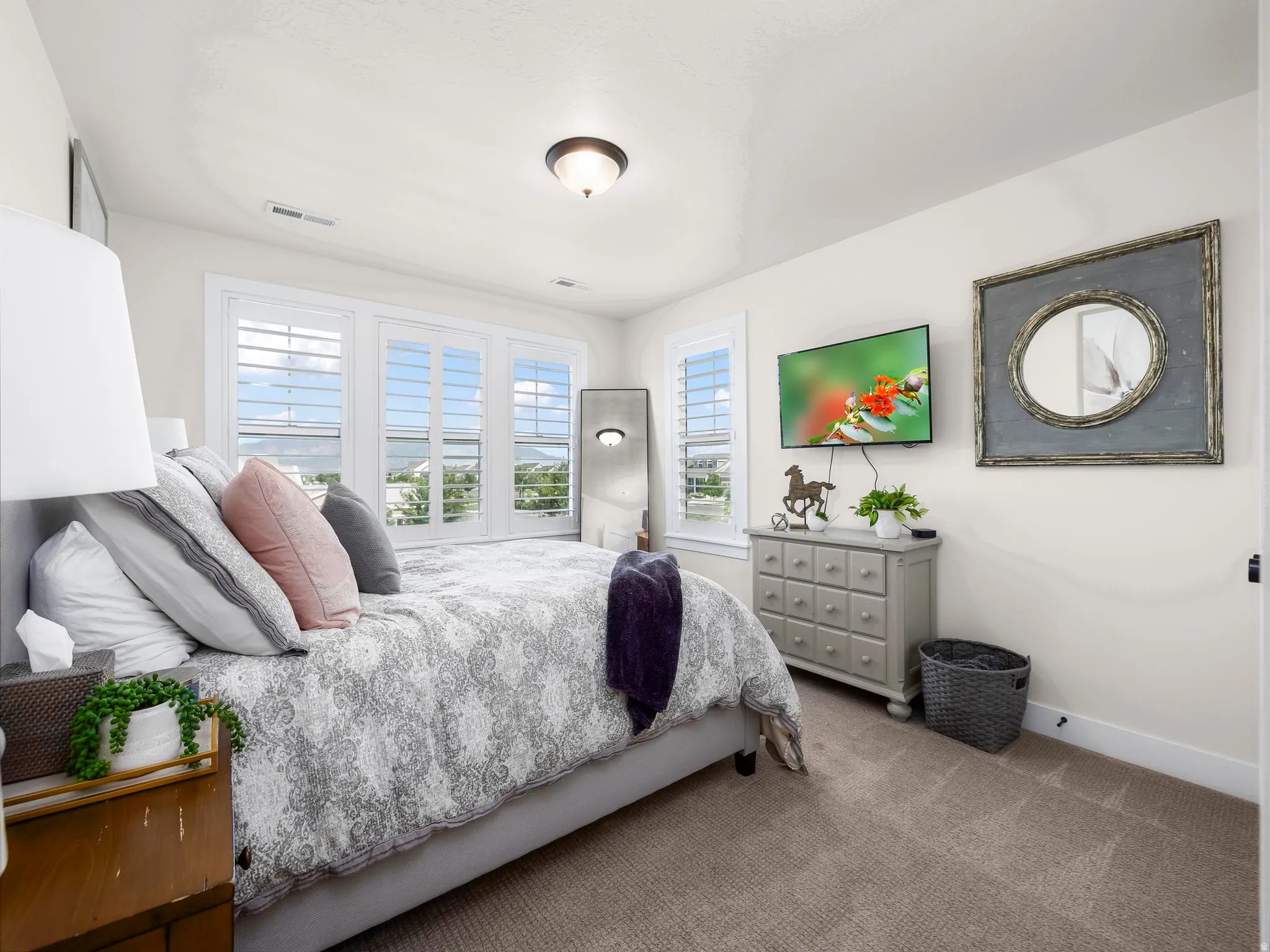 Bedroom featuring natural light, white plantation shutters, vaulted ceiling, recessed lighting, and carpeted flooring
