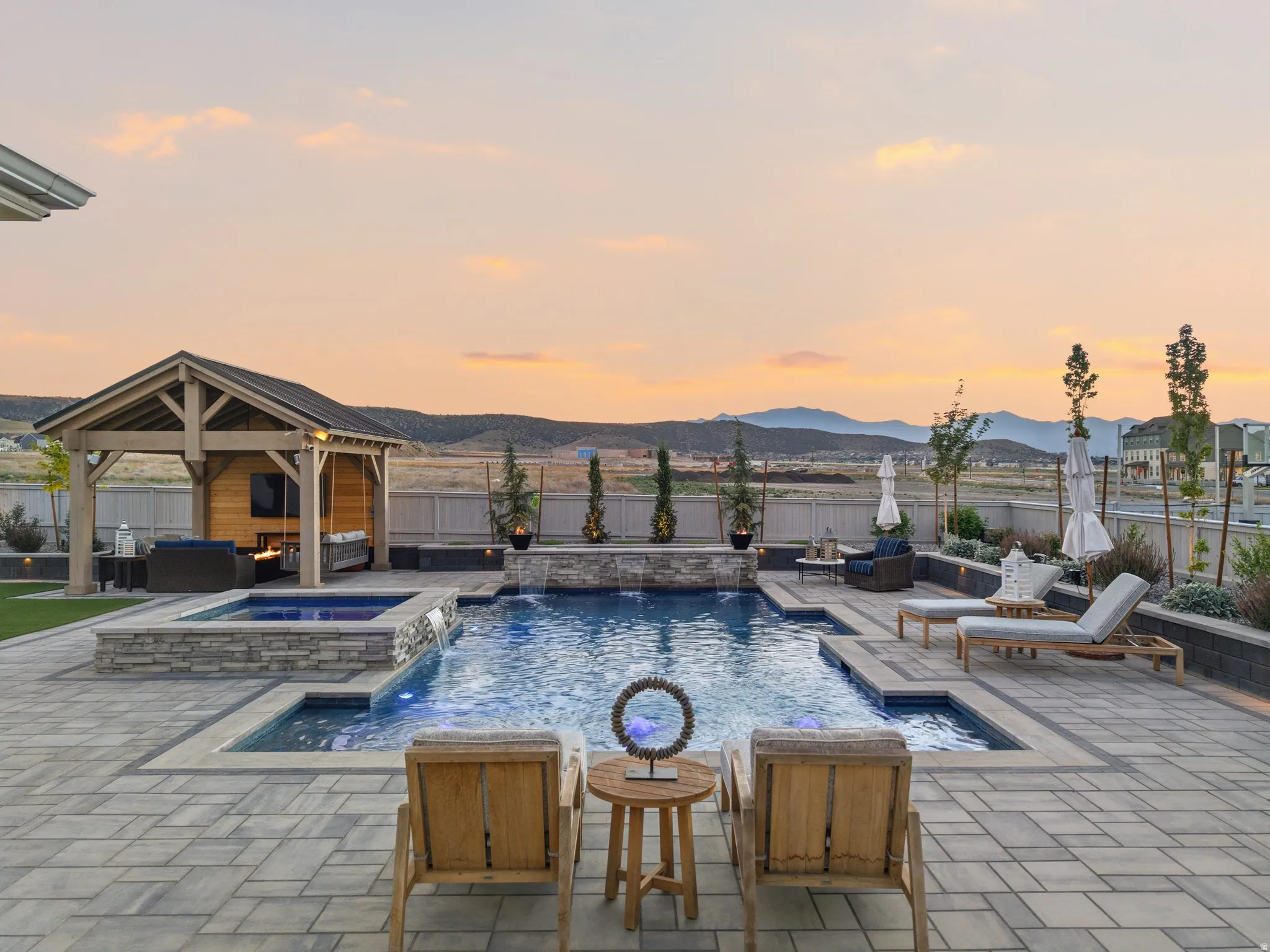 Expansive paver patio with a custom pool and integrated spa