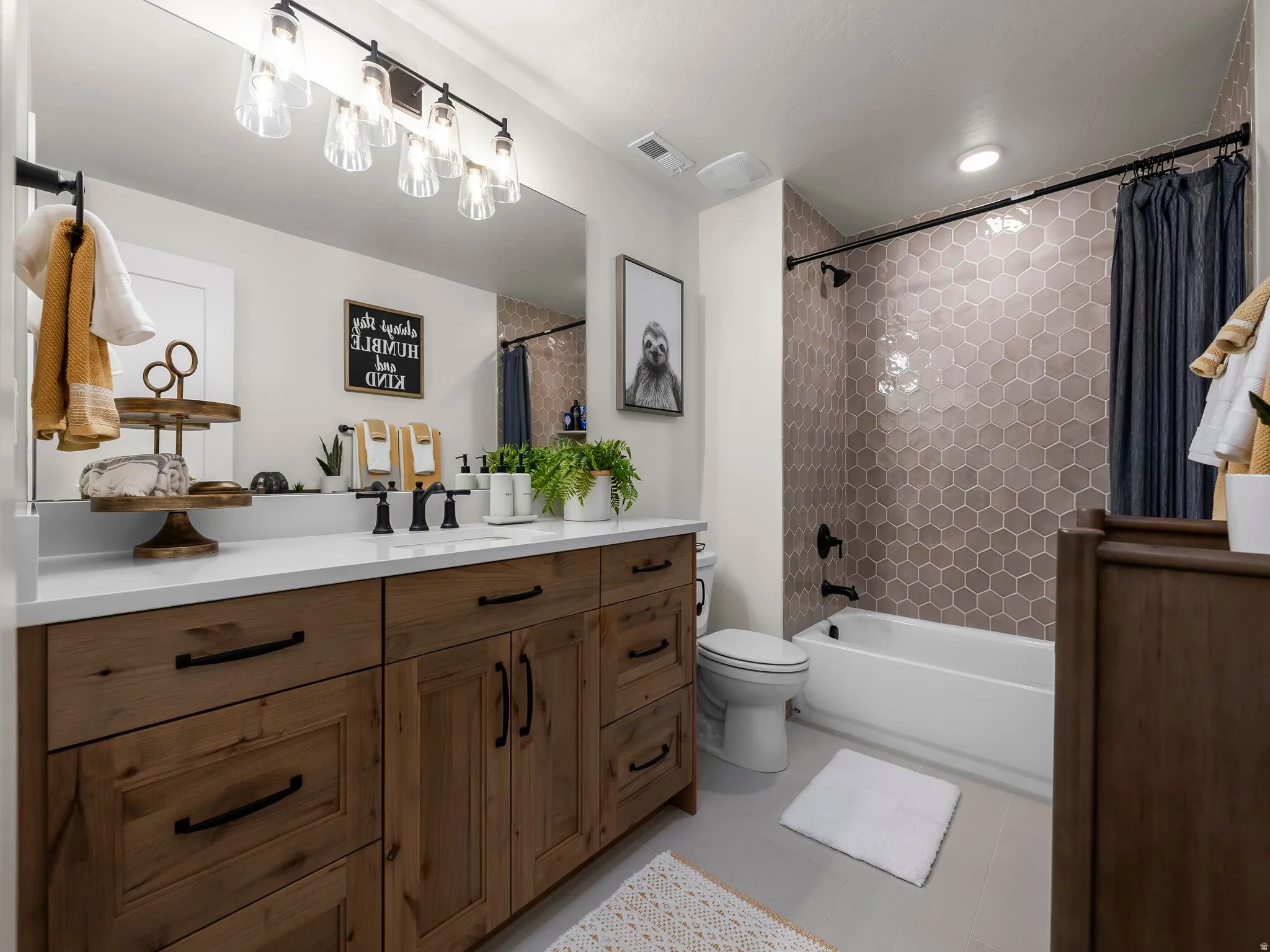Bathroom featuring a wood-finish vanity with ample storage and a white countertop