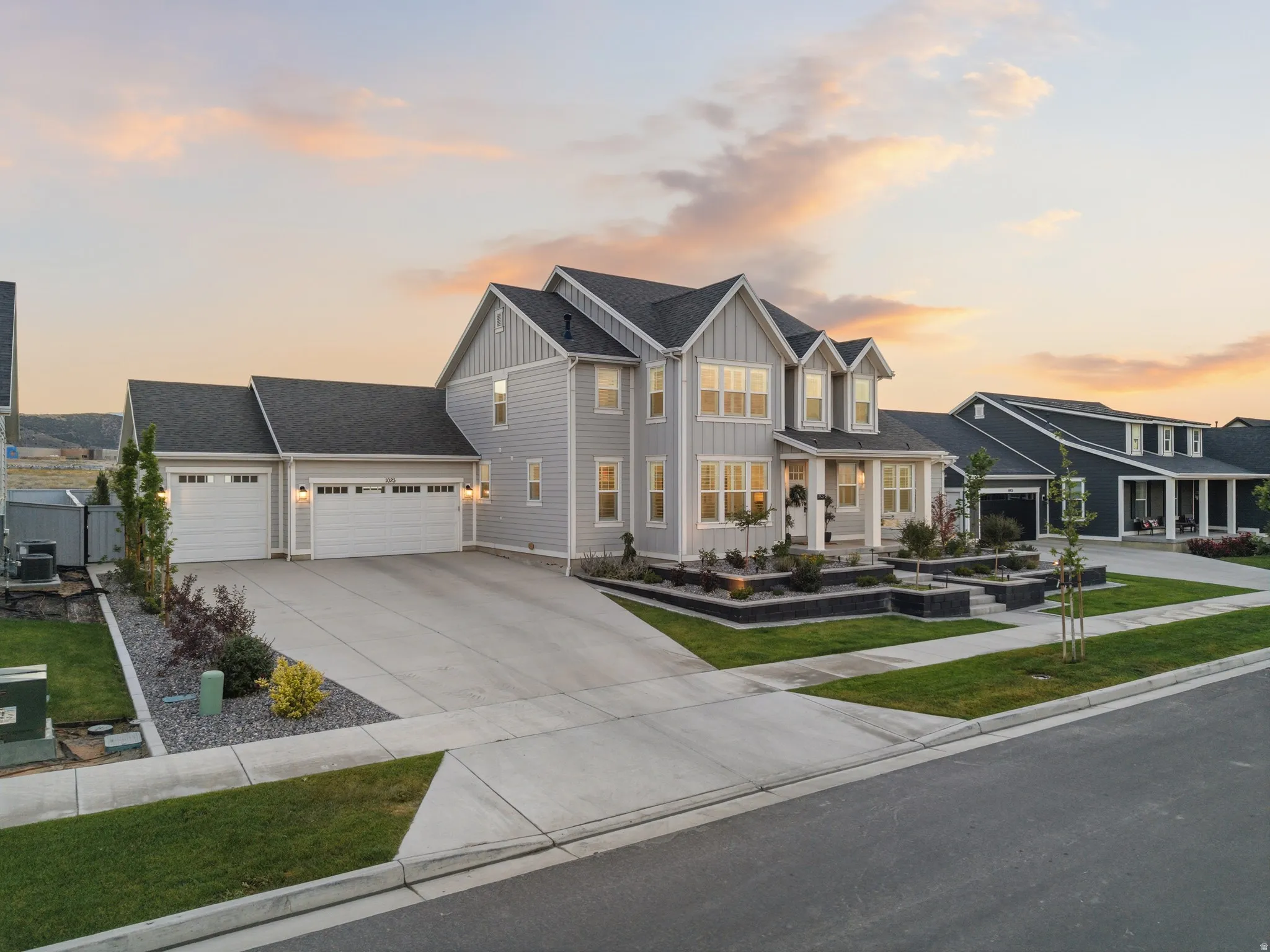 Contemporary two-story residence featuring light gray siding and dark gray roofing