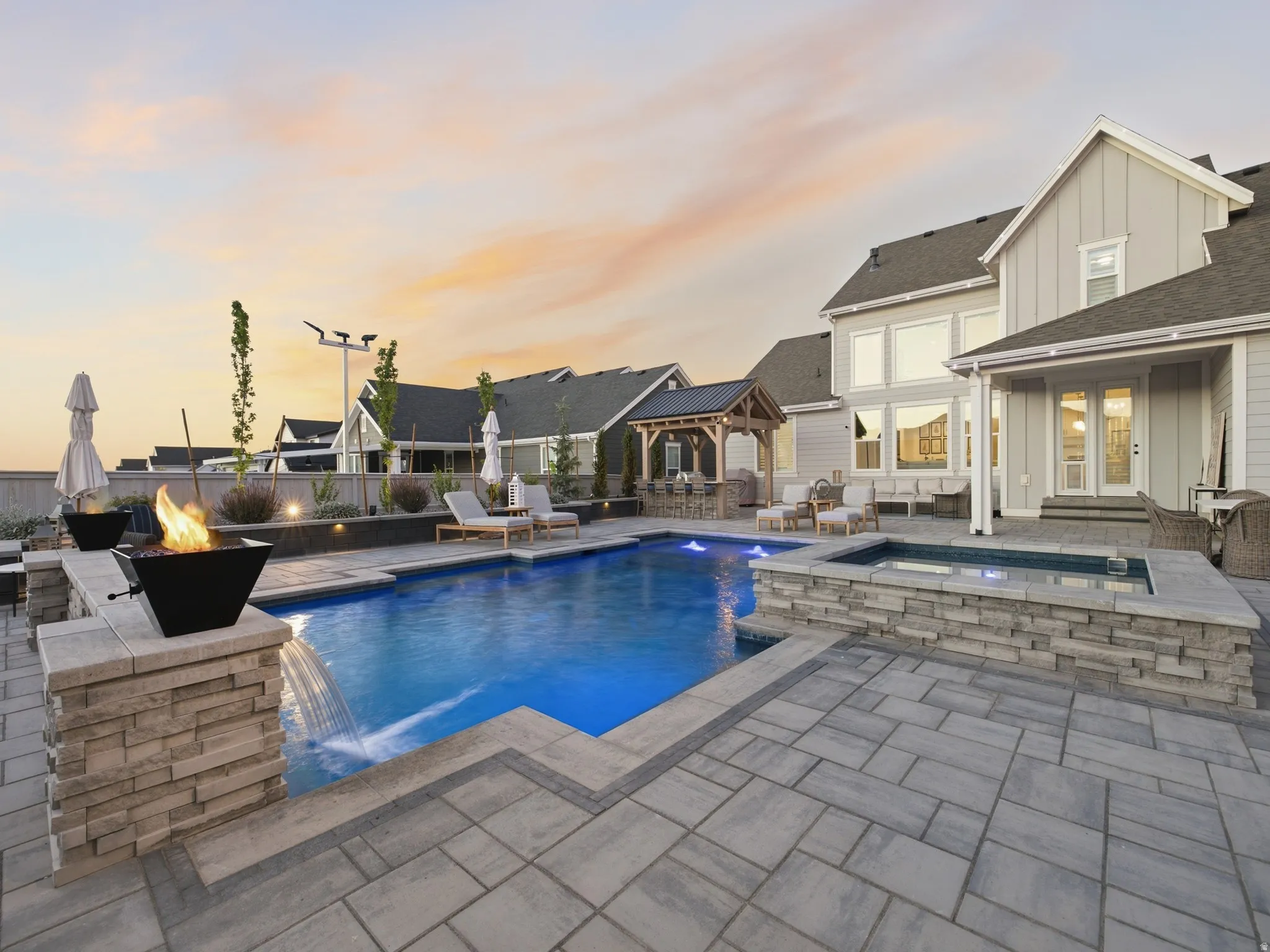 Expansive paver patio with a swimming pool and integrated spa