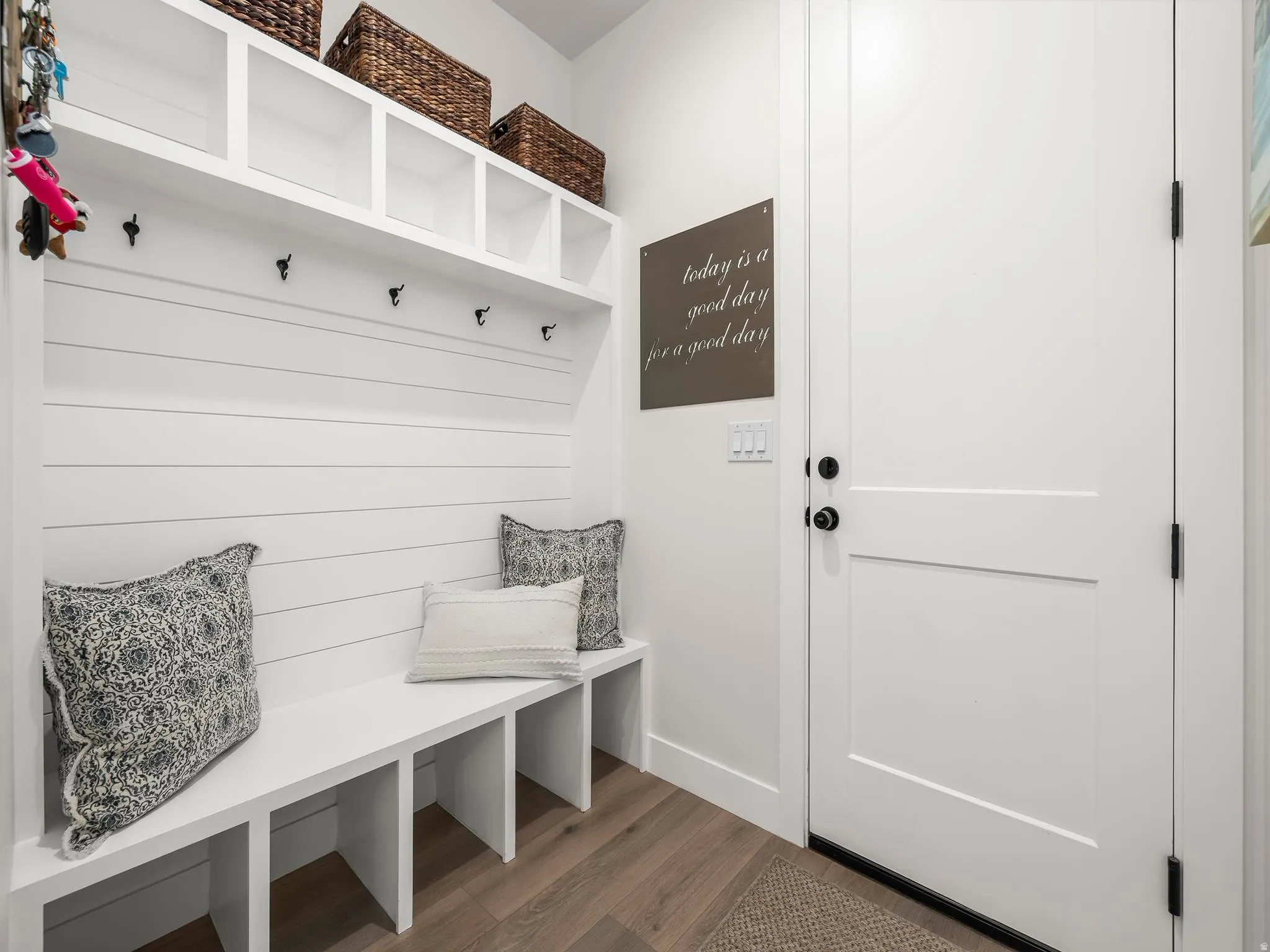Built-in mudroom bench with cubbies, upper shelving, and wall hooks