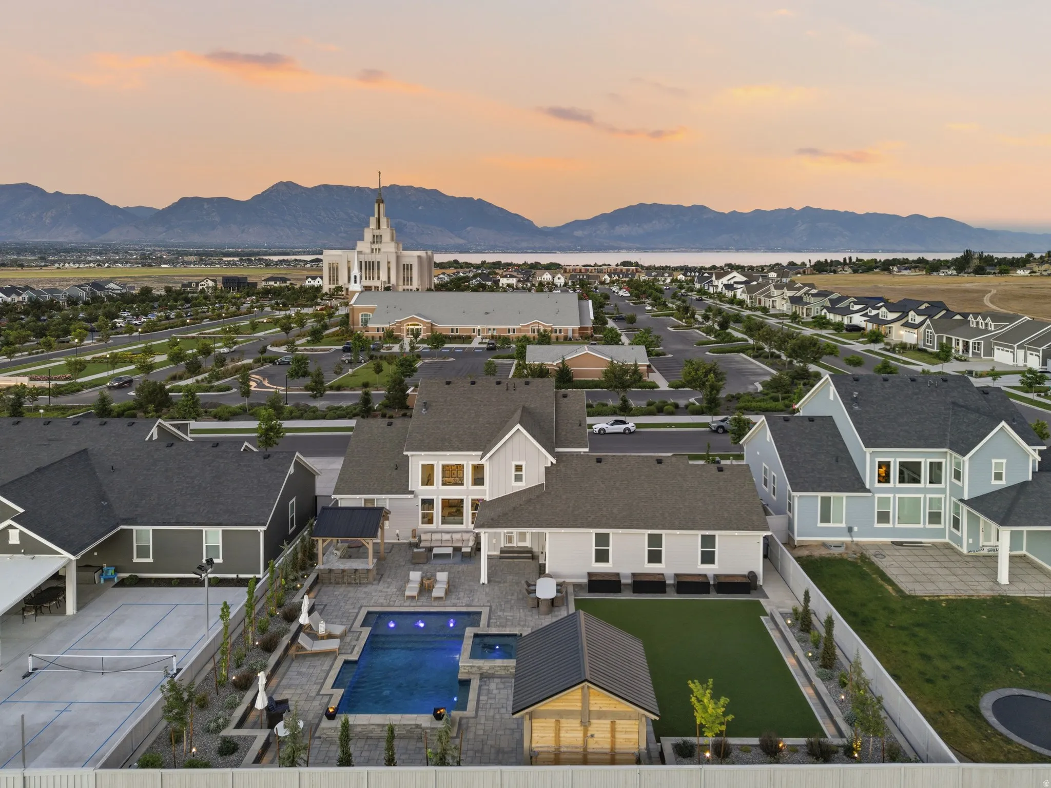 Expansive backyard featuring a sparkling blue swimming pool, integrated spa, and a dedicated artificial turf area
