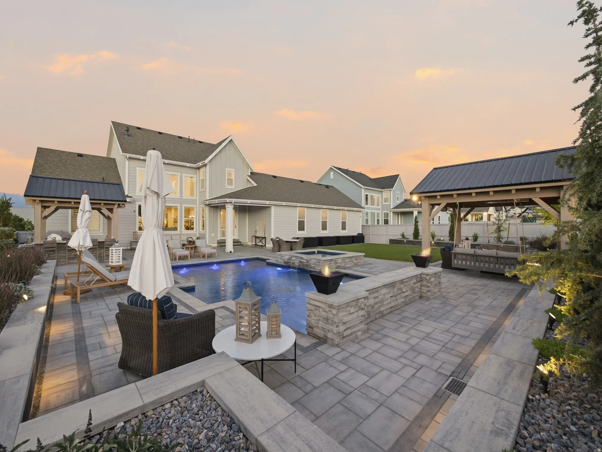 Expansive paver patio featuring a built-in swimming pool with an integrated spa